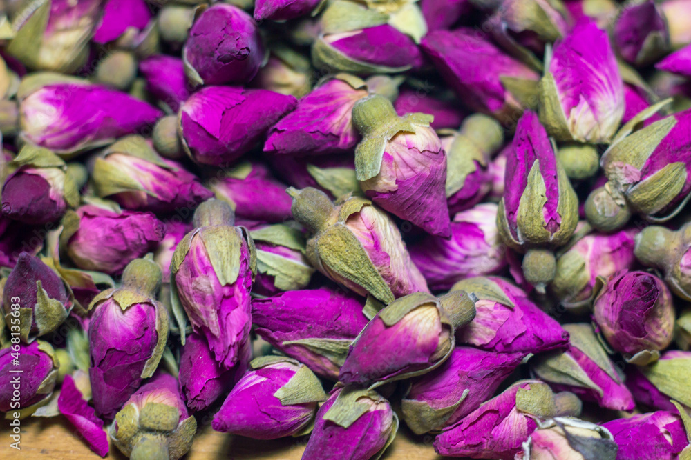 Macro picture of Dried Purple Rose buds on the wood plate.Aromatic of rose for tea .Harvest ,House plants ,Organic garden .