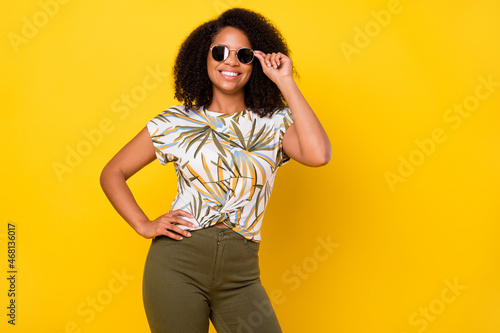 Photo of young attractive african woman good mood eyewear summer isolated over yellow color background