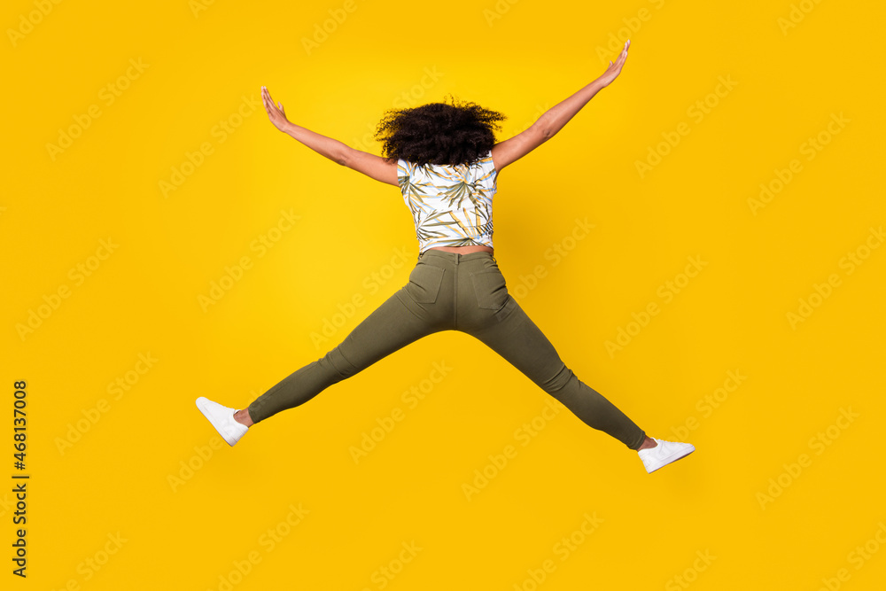 Back rear view full length photo of young african woman jump incognito isolated over yellow color background - obrazy, fototapety, plakaty 