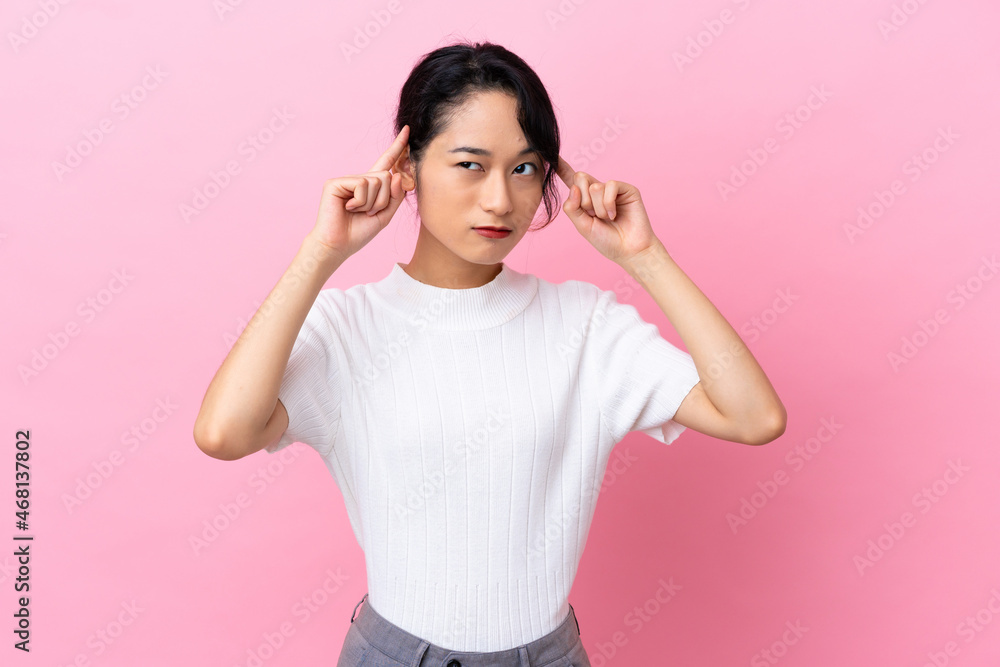 Young Vietnamese woman isolated on pink background having doubts and thinking Young Vietnamese woman isolated on pink background having doubts and thinking