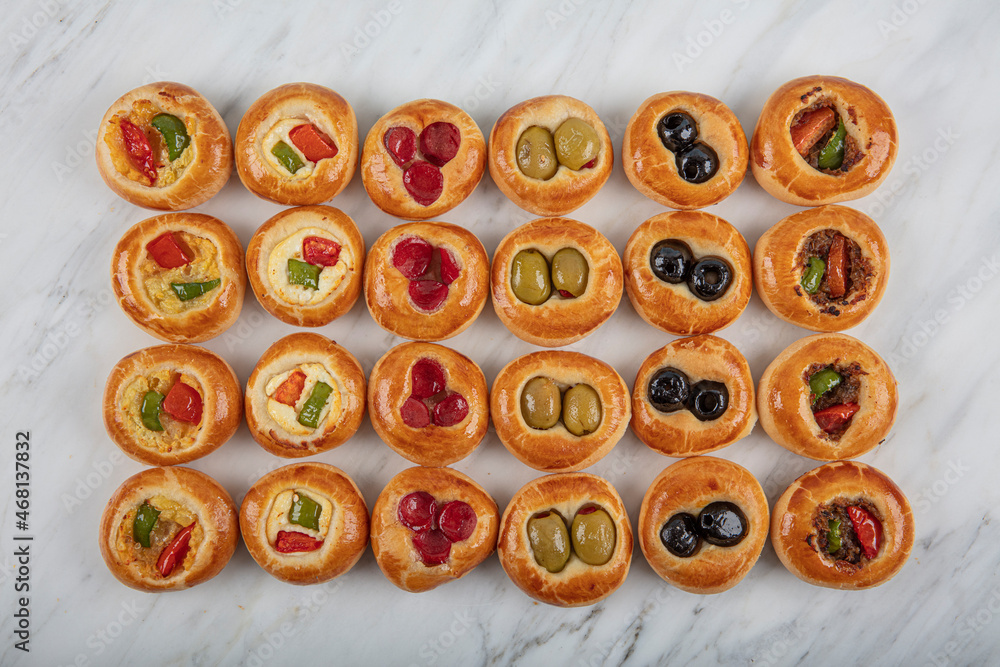 Mini Hot Dogs served as open buffet. Mini pizzas with assorted vegetables, mozzarella cheese and fresh basil on marble background, close-up, top view. Mini Hot Dogs served as open buffet. Mini pizzas with assorted vegetables, mozzarella cheese and fresh basil on marble background, close-up, top view.