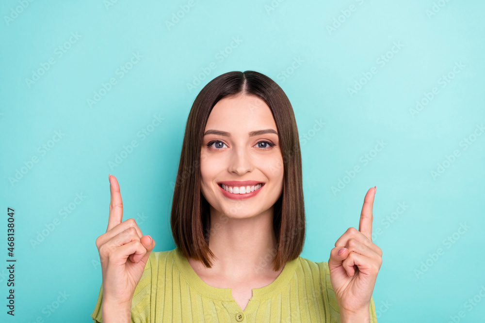 Photo of lovely promoter cute lady indicate sale empty space banner wear green blouse isolated teal color background Photo of lovely promoter cute lady indicate sale empty space banner wear green blouse isolated teal color background
