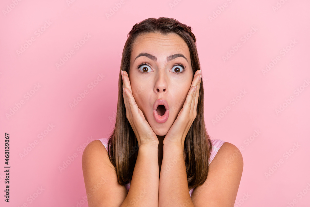 Photo of amazed shocked astonished young woman hold hands face wow news sale isolated on pink color background Photo of amazed shocked astonished young woman hold hands face wow news sale isolated on pink color background