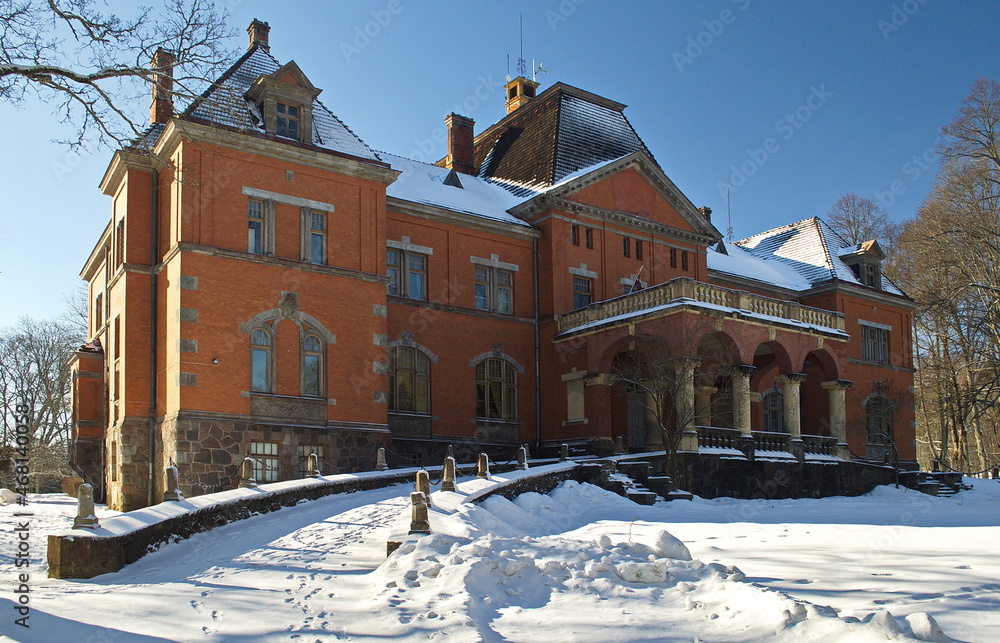 Red brick Pelci manor in sunny winter day, Pelci, Latvia.