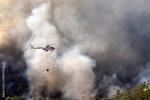 The helicopter is in smoke.A helicopter extinguishes a fire in the forest. Forest fire in the resort village of Ichmeler.