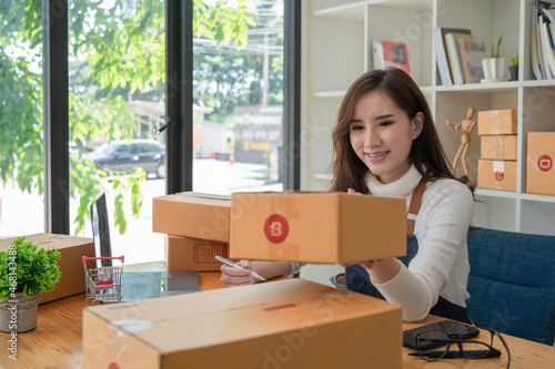 Young Asian women working with a box for packaging order from shopping online in home, Own Business Startup	