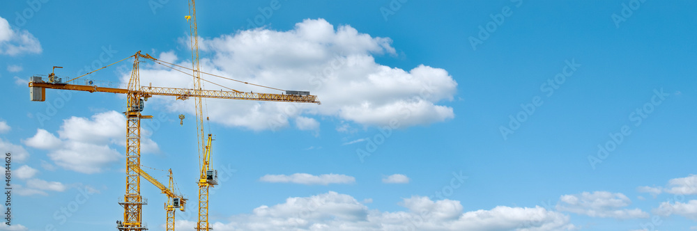 Panorama with many tower cranes in clear blue sky with clouds Panorama with many tower cranes in clear blue sky with clouds
