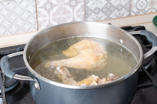 Saucepan with bouillon on the stove. Chicken bouillon