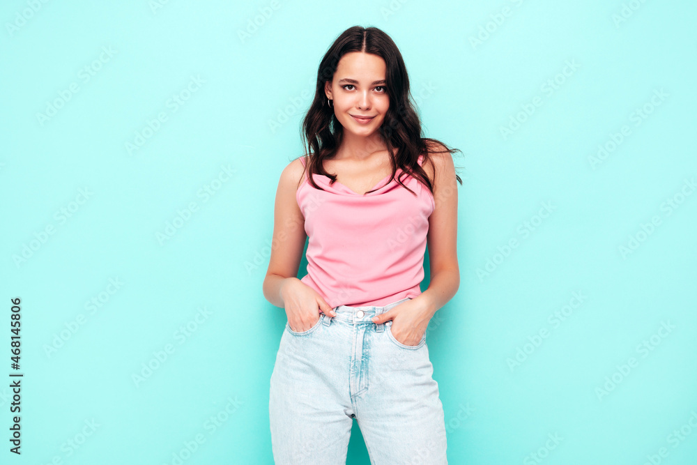 Young beautiful smiling female in trendy summer clothes. Sexy carefree woman posing near blue wall in studio. Positive brunette model having fun and going crazy. Cheerful and happy Young beautiful smiling female in trendy summer clothes. Sexy carefree woman posing near blue wall in studio. Positive brunette model having fun and going crazy. Cheerful and happy