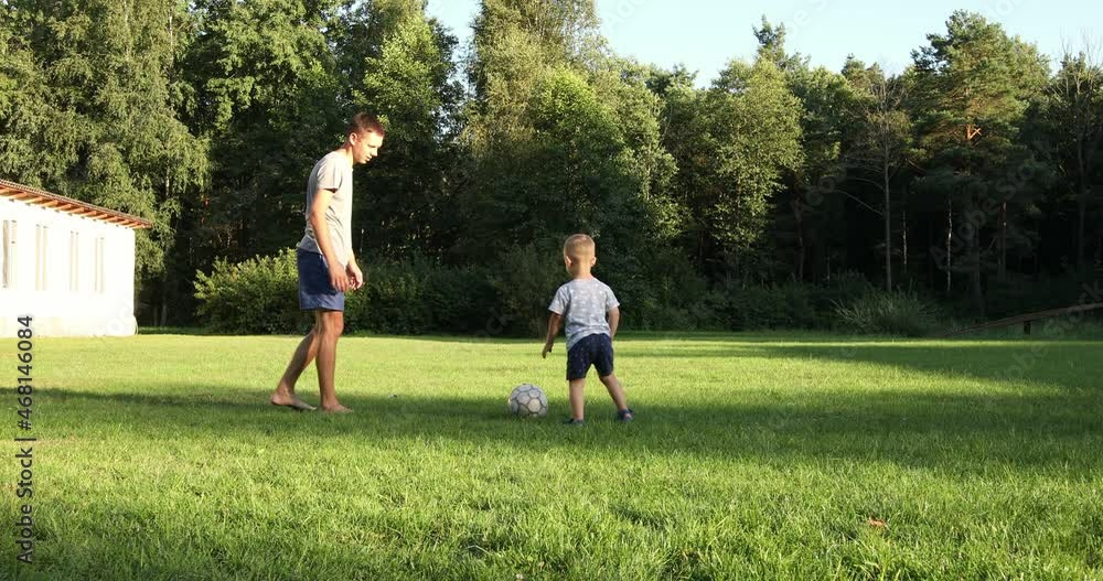 father and boy play football in nature father and boy play football in nature