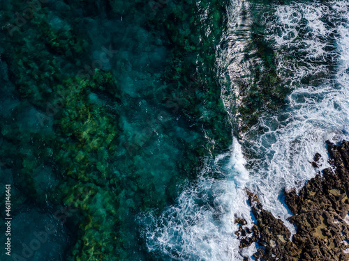 Top view of sea waves and rocky coastline