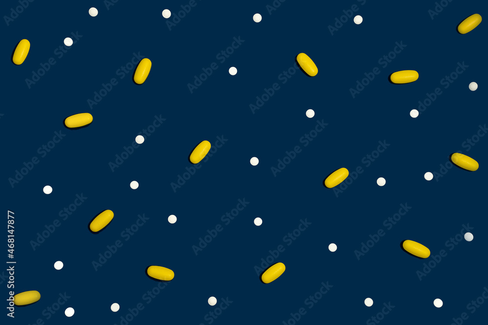 Blue background with many drugs in capsules and tablets of different colors scattered on the surface Blue background with many drugs in capsules and tablets of different colors scattered on the surface