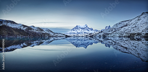 Winter in Patagonia: snow covered hills and mountains reflect in the Serrano river in Torres del paine National Park, Chile in the blue hour just after sunset