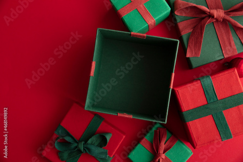 Open festive christmas present box on a red background. Flat lay, top view