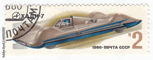 Macro view of vintage postage stamp with a sport car. Perforated postage stamp country 1980 year. Used paper stamp depicting auto sport transport 1980 year - Hadi car. circa. Cool philatelic hobby.