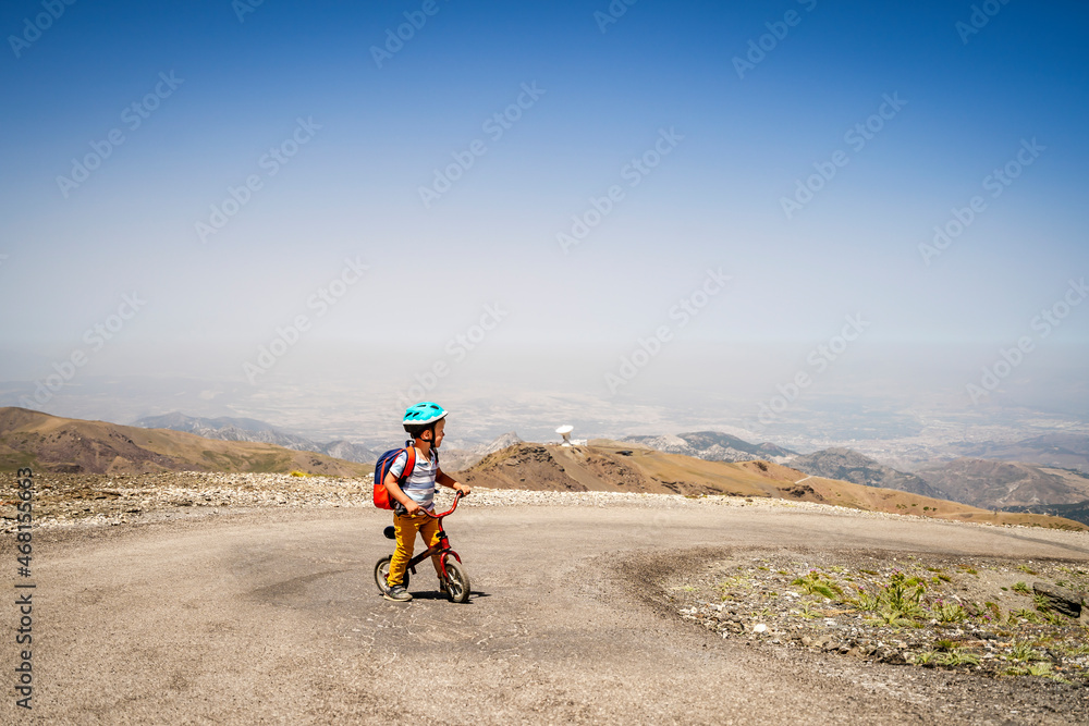 Small boy riding uphill on his first bicycle in Sierra Nevada mountains, Spain Small boy riding uphill on his first bicycle in Sierra Nevada mountains, Spain