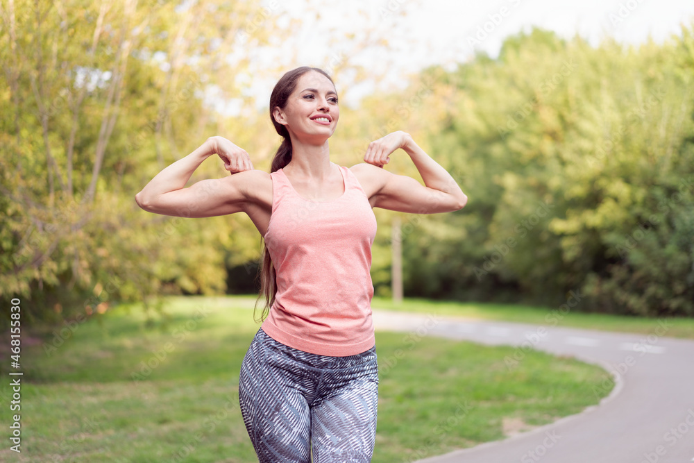 Woman runner stretching arms before running summer park Woman runner stretching arms before running summer park