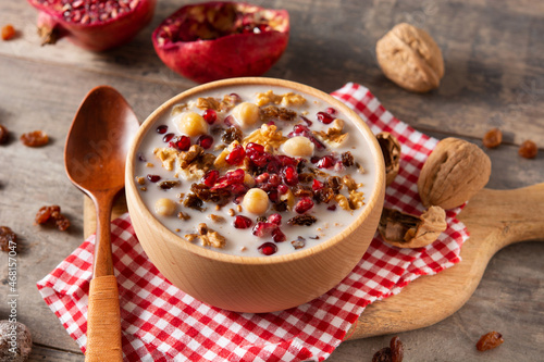 Traditional Turkish Noah's pudding in bowl on wooden table	 photo