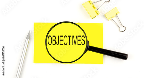 OBJECTIVES text on the sticker through magnifier. View from above. Business concept