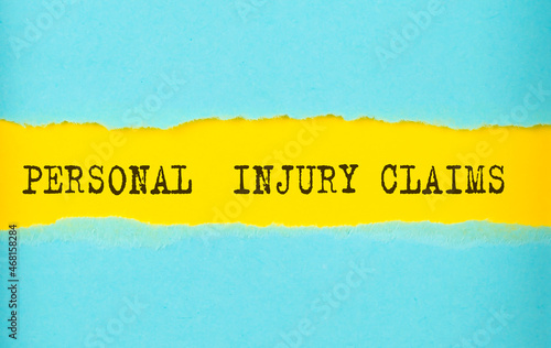 Personal Injury Claims text on the torn paper , yellow background photo