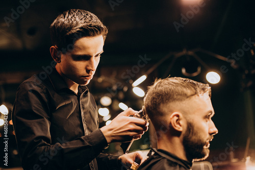 Young man at barbershop trimming hair