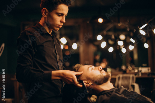 Young man at barbershop trimming hair