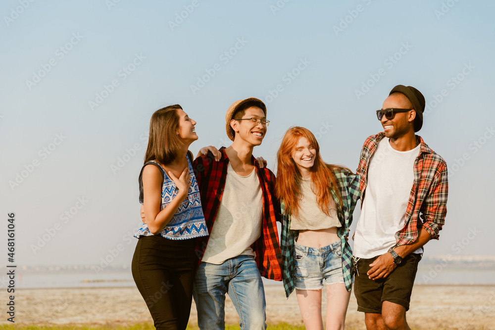 Young multiracial friends hugging and smiling together Young multiracial friends hugging and smiling together