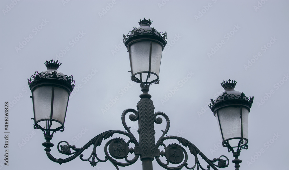Close-up of street lamps in the morning of a cloudy day in the center of Seville.