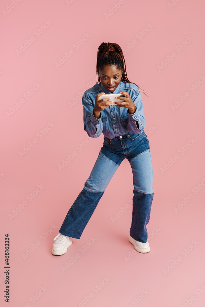 Young black woman playing online game on mobile phone Young black woman playing online game on mobile phone