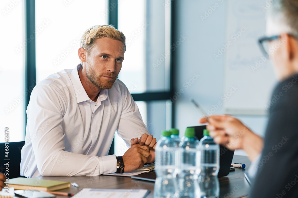 Adult white men discussing business project during meeting in office Adult white men discussing business project during meeting in office