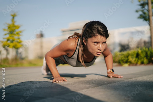  Beautiful athlete woman in sportswear outdoors. Young woman training in the park. Healthy lifestyle.