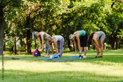 Multiracial women doing exercise during yoga practice in park