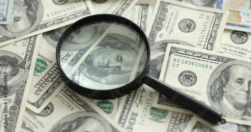 Magnifying glass lying on lot of paper dollar bills closeup 4k movie slow motion Magnifying glass lying on lot of paper dollar bills closeup 4k movie slow motion