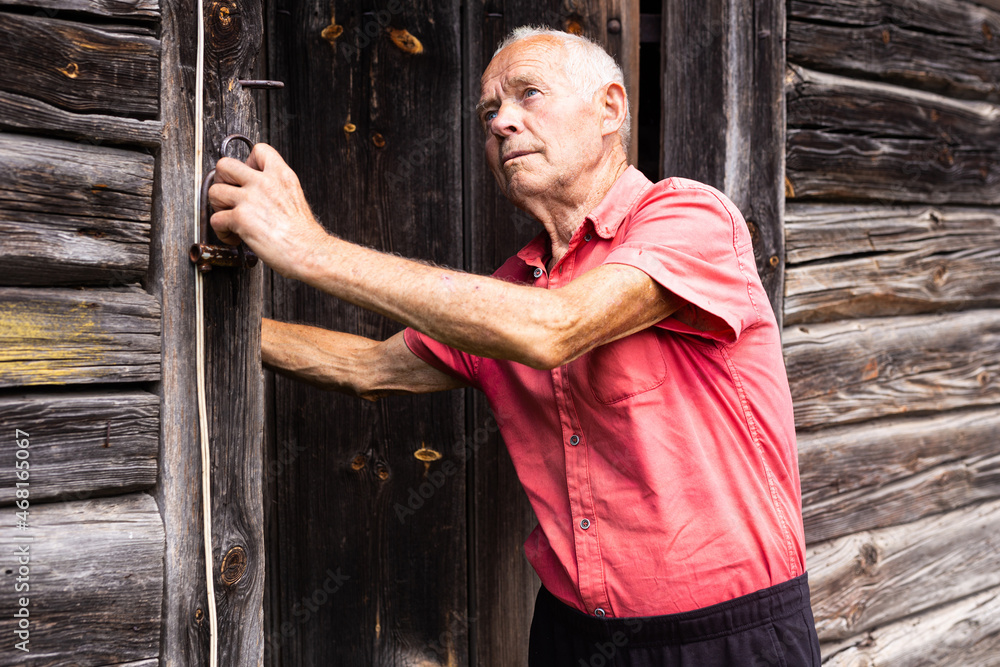 senior pensioner in red polo posing near the house in the village senior pensioner in red polo posing near the house in the village
