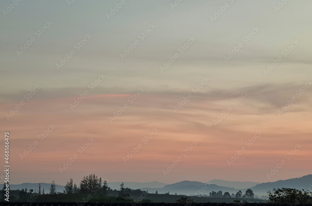 Morning blur over mountains and trees. The first and last light of the day in sky Morning blur over mountains and trees. The first and last light of the day in sky