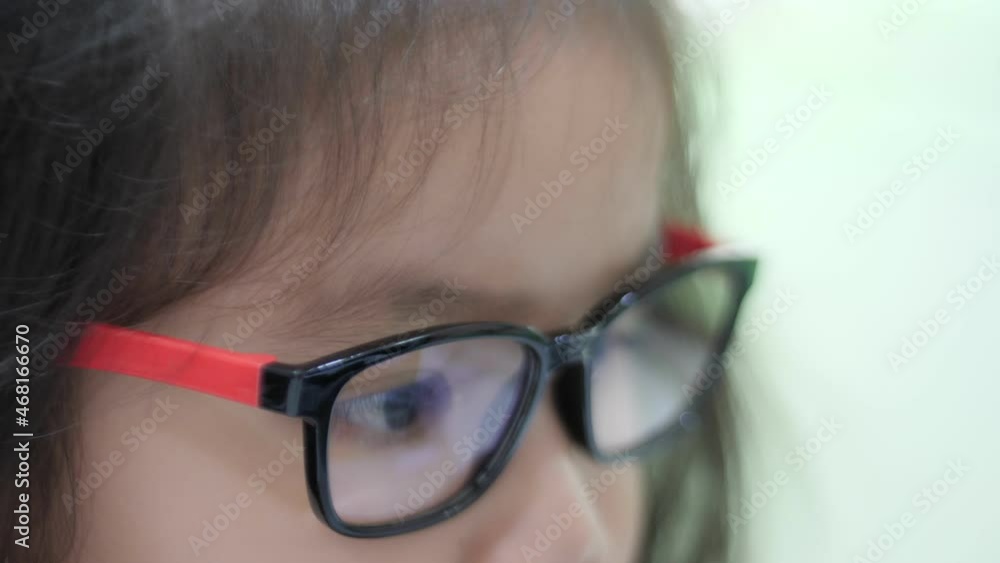 Slow motion scene of 4-5 year old Asian girl. Close-up of a businessman determined to wear computer glasses to reduce eye strain when double vision. Look at the computer screen with a reflection of th Slow motion scene of 4-5 year old Asian girl. Close-up of a businessman determined to wear computer glasses to reduce eye strain when double vision. Look at the computer screen with a reflection of th