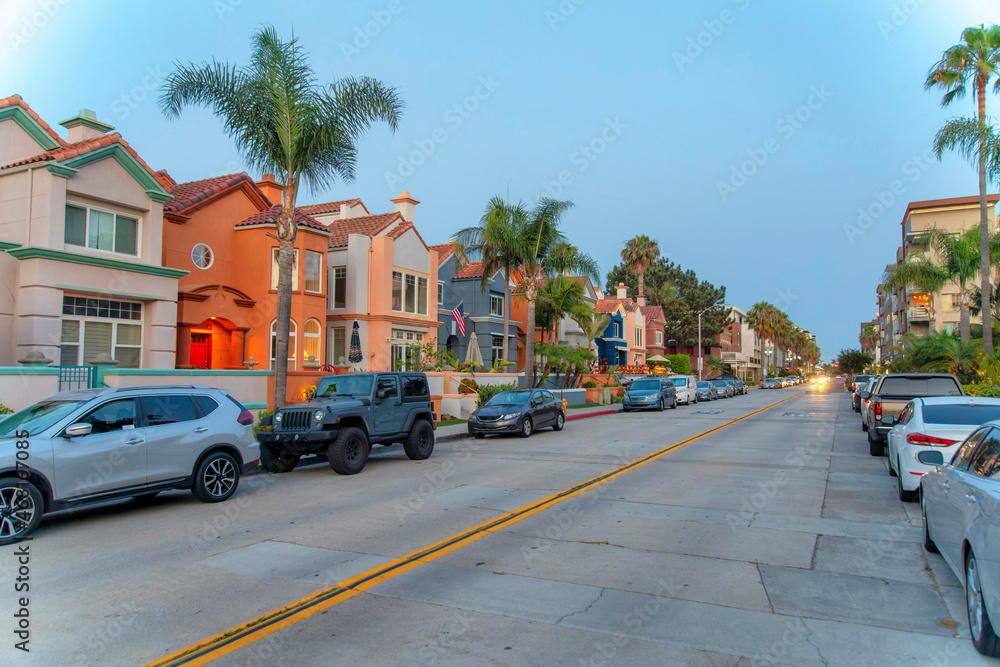 Road in the middle of the residential buildings with parked vehicles at Oceanside, California