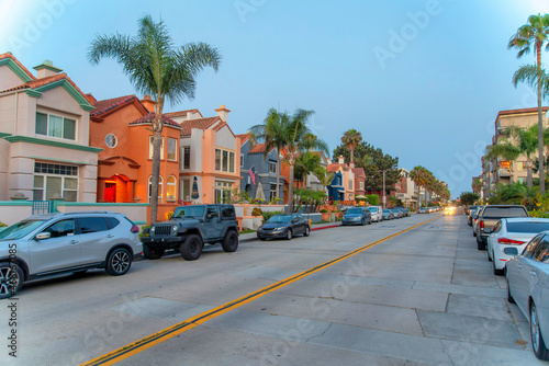 Road in the middle of the residential buildings with parked vehicles at Oceanside, California