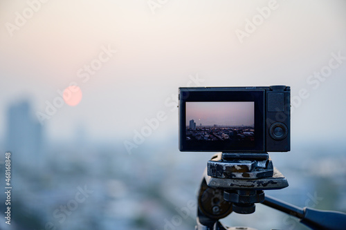 Digital camera put on the tripod for shoot something with landscape of bangkok in display or live view