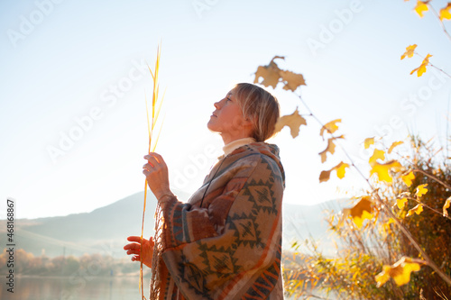 Portrait of woman dressed in poncho and look to the lake, enjoy life, happy in moment © Вероника Зеленина