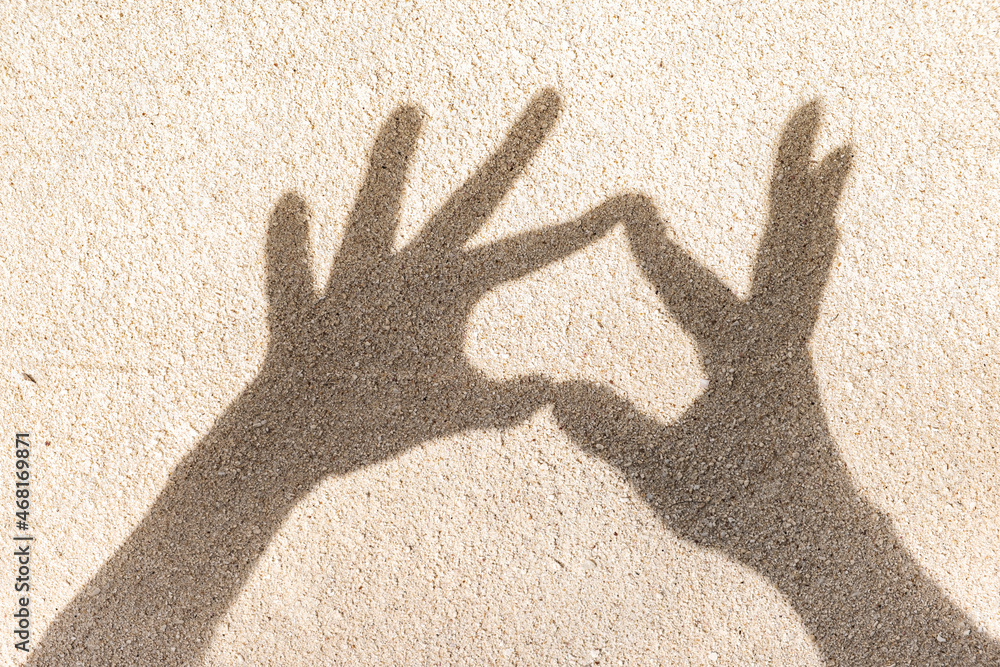Heart shape shadow on sand, top view, copy space