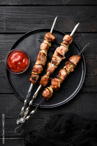 Shish kebab of pork, on black wooden table background, top view flat lay, with copy space for text