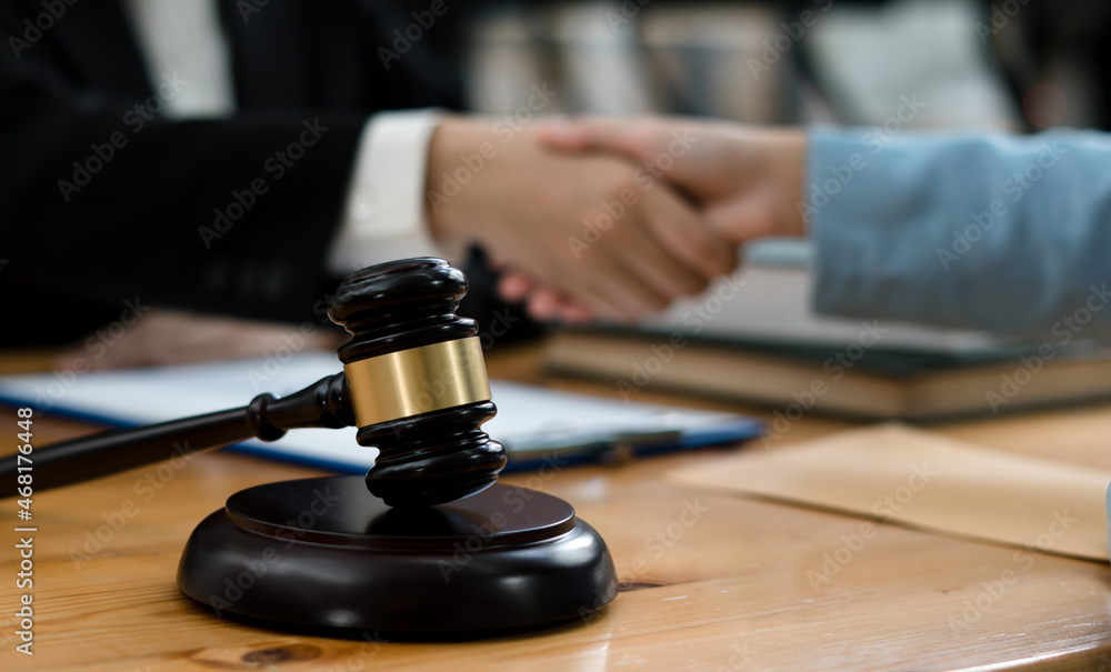 Businessman shaking hands to seal a deal with his partner lawyers or attorneys discussing a contract agreement.Legal law, advice, and justice concept. Businessman shaking hands to seal a deal with his partner lawyers or attorneys discussing a contract agreement.Legal law, advice, and justice concept.
