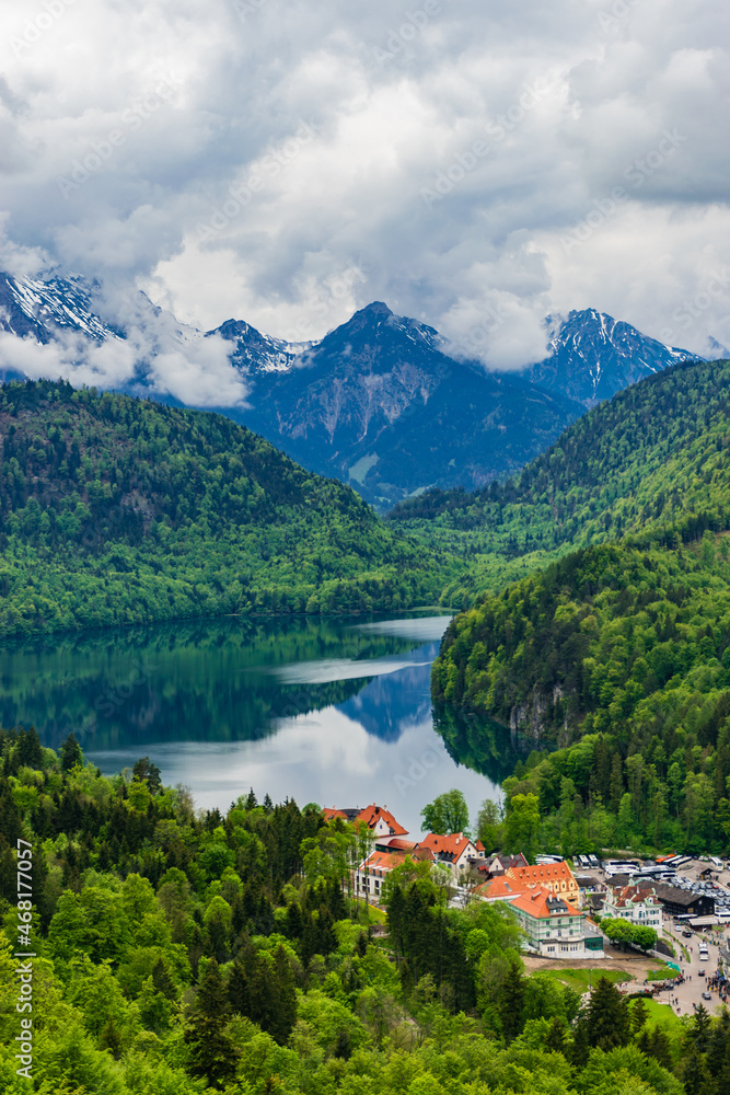 26 May 2019 Fussen, Germany - Hohenschwangau castle among green springtime Alpine mountains. Fussen village, Alpsee and Forggensee lake