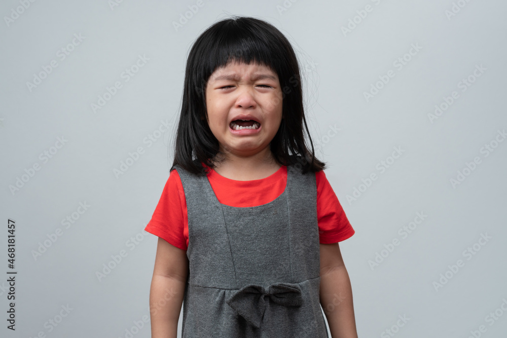 Portrait of Asian angry, sad and cry little girl on white isolated background, The emotion of a child when tantrum and mad, expression grumpy emotion. Kid emotional control concept Portrait of Asian angry, sad and cry little girl on white isolated background, The emotion of a child when tantrum and mad, expression grumpy emotion. Kid emotional control concept