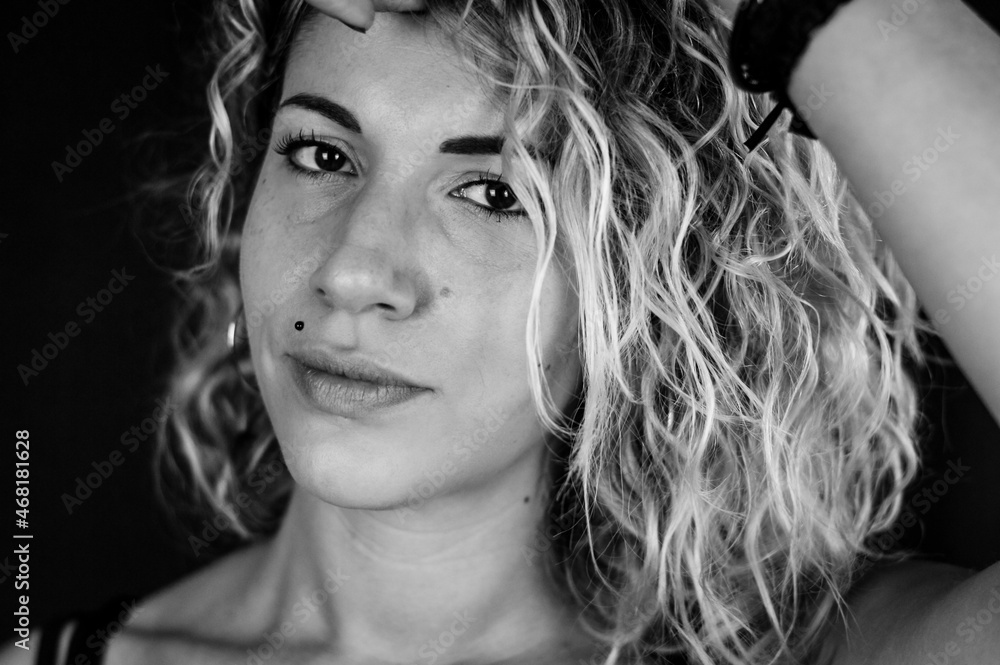 Close up black and white portrait of a beautiful young woman with blonde and curly hair Close up black and white portrait of a beautiful young woman with blonde and curly hair