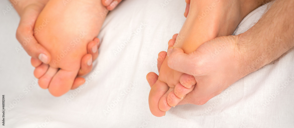 Relaxing double massage on the female feet by two masseurs in spa salon Relaxing double massage on the female feet by two masseurs in spa salon