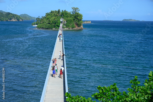 pedestrian bridge beetween islands in samana touristic city. HD photo shows a bridge between islands in the Caribbean. Samana city in the Dominican Republic. On the bridge you can see people, tourists