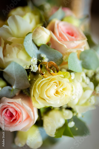 Wedding rings on a petal of a rose. Concept for a wedding card. The bride's bouquet. High quality photo