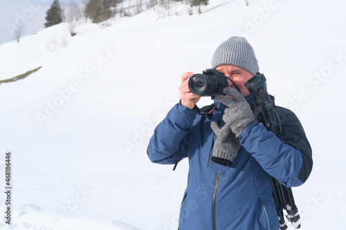 elderly man with camera, mountain hiker admiring mountain winter landscape, Sports Concept, Healthy Lifestyle, Winter Activity, beautiful winter natural landscape, walks in winter white forest